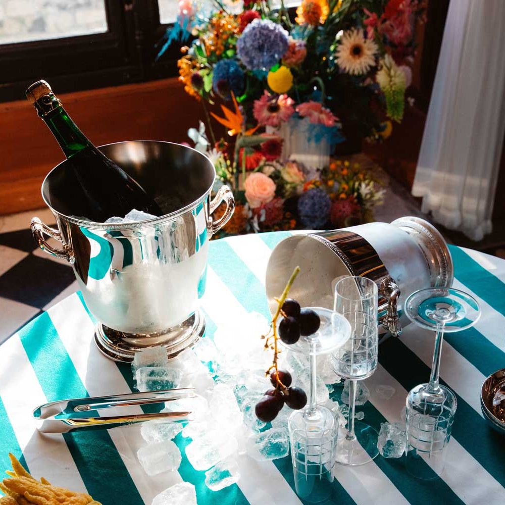 table set for drinks, champagne bottle served in christofle malmaison silver-plated champagne cooler bucket