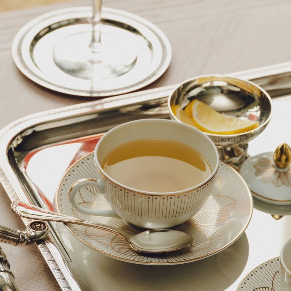 Christofle Malmaison Porcelain Tea Cup and Saucers Gold Finish in porcelain on a white background