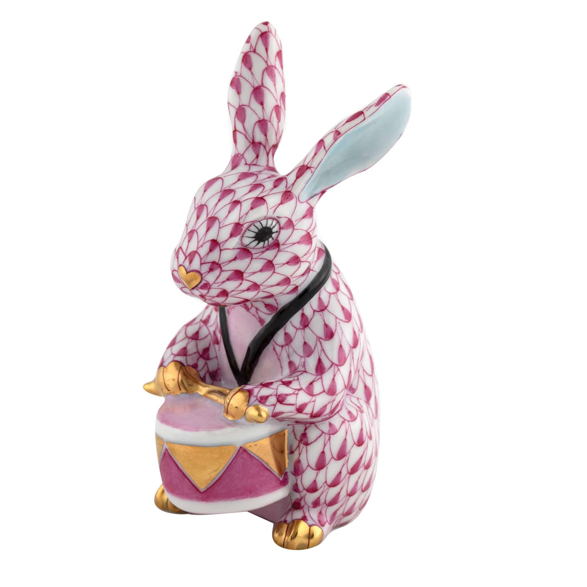 Herend Drummer Bunny figurine in Raspberry with raspberry pink fishnet pattern with gold accents on a white background