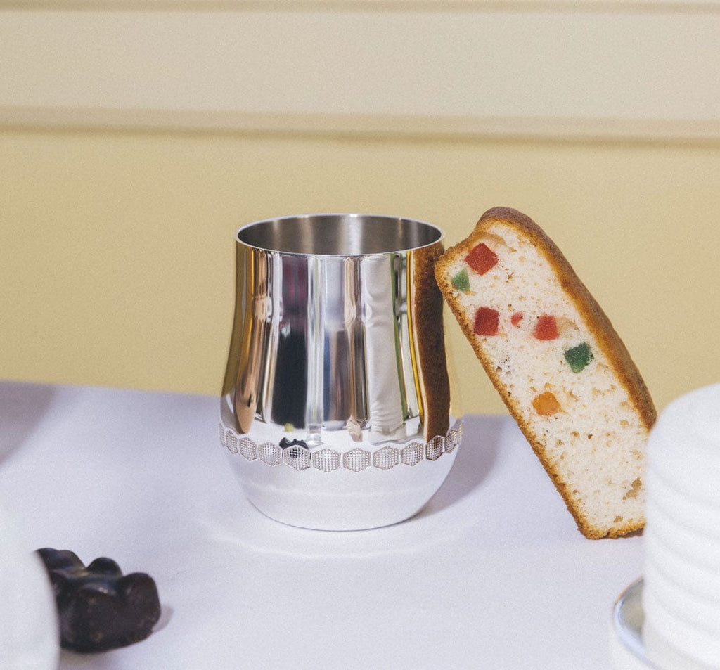 christofle beebee silver-plated baby cup, no handles, with a fruit cake leaning on it