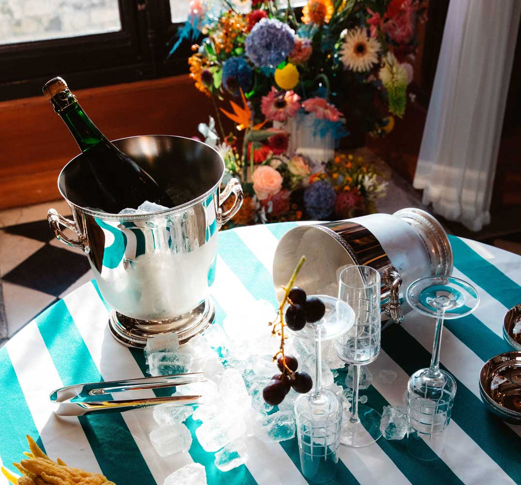 table set for drinks, champagne bottle served in christofle malmaison silver-plated champagne cooler bucket 