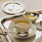 Christofle Malmaison Porcelain Tea Cup and Saucers Gold Finish in porcelain on a white background