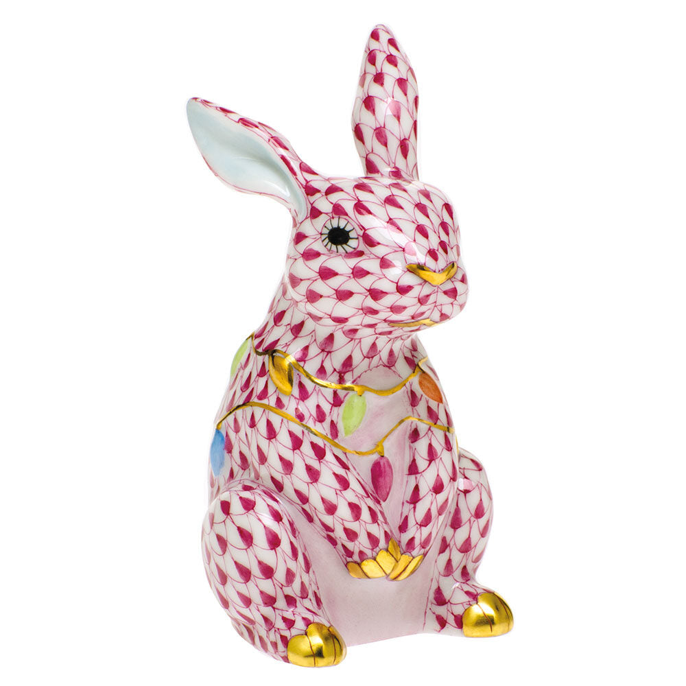 Hand-painted Herend Bunny with Christmas Lights Figurine in Raspberry fishnet porcelain on a white background
