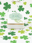 Decorative clover box with gilded sides surrounded by green and keylime clovers
