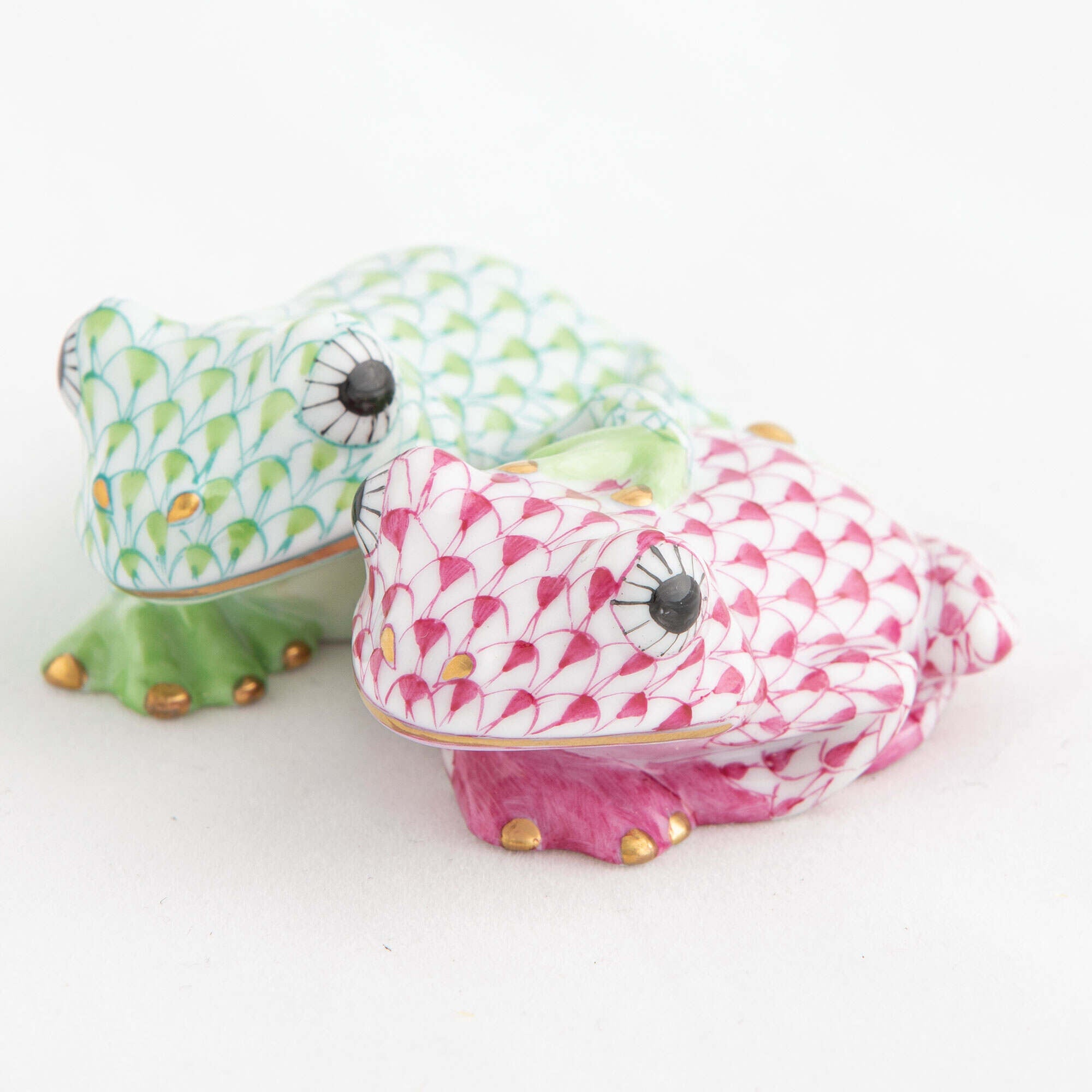 Hand-painted Herend Pair of Frogs Figurine in Key Lime-Raspberry fishnet porcelain on a white background