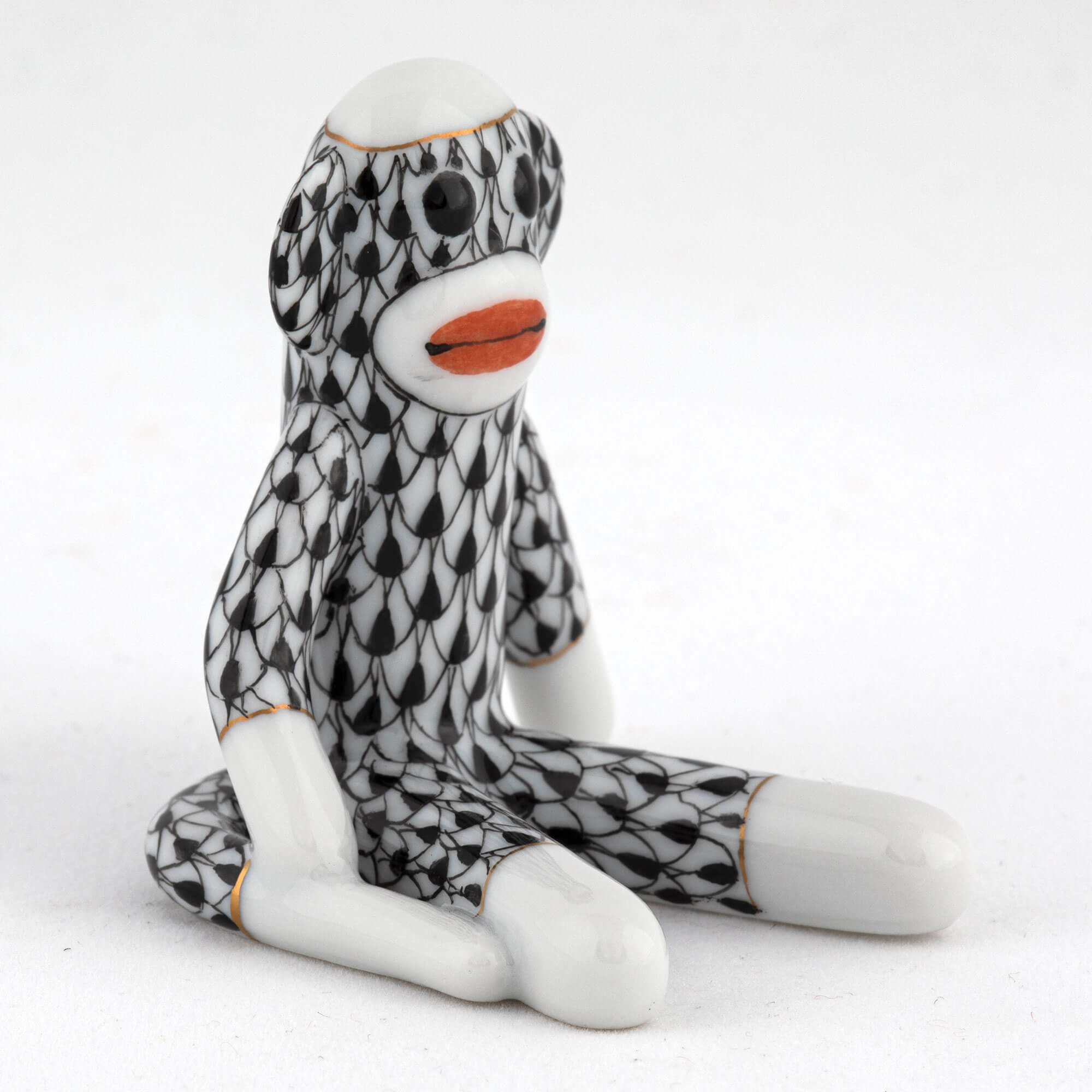 Herend Sock Monkey figurine in Black with black fishnet pattern with gold accents on a white background